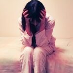 頭をかかえる若い女性