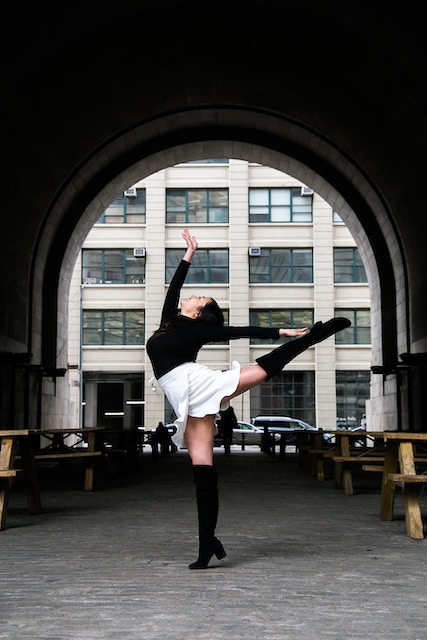 female dancer posing in front of a modern building